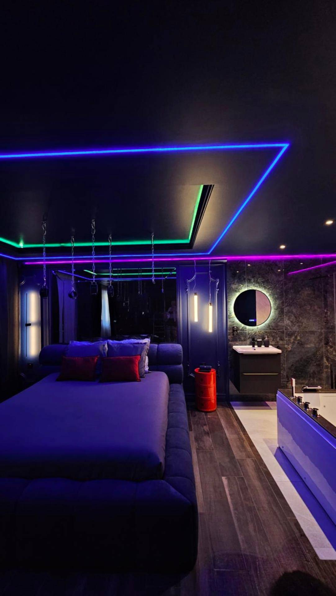 Chambre avec lit king size et néons colorés - Love Room Cannes - Love room - Xtase By luxuria Cannes