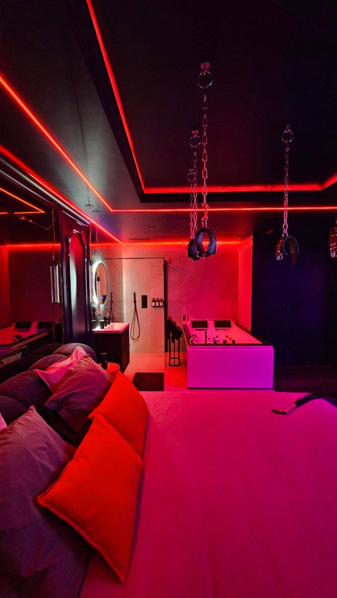 Lit avec coussins rouges et menottes au plafond - Love room - Xtase By luxuria Cannes