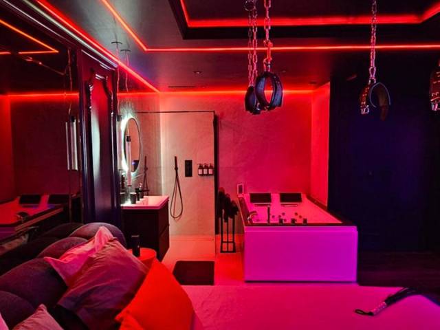 Lit avec coussins rouges et menottes au plafond - Love room - Xtase By luxuria Cannes