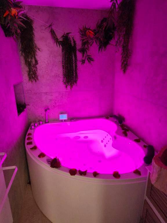 Baignoire balnéo avec éclairage rose et pétales - Love Room Hyères - Zen room - Havre de paix